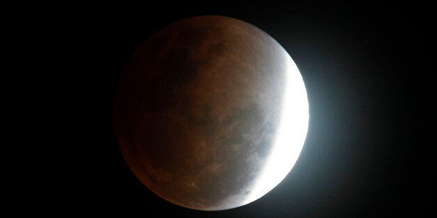 The moon seen from Manila, Philippines, during a total lunar eclipse Saturday Dec. 10, 2011, as the Earth casts a shadow across the face of the moon.   Passing clouds hampered the evening spectacle in some parts of the Philippines.  (AP Photo/Bullit Marquez)