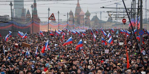 People carry Russian national flags during a march in memory of opposition leader Boris Nemtsov who was gunned down on Friday, Feb. 27, 2015 near the Kremlin, with The Kremlin Wall and St. Basil Cathedral in the background  in Moscow, Russia, Sunday, March 1, 2015. Thousands converged Sunday in central Moscow to mourn veteran liberal politician Boris Nemtsov, whose killing on the streets of the capital has shaken Russiaâs beleaguered opposition. They carried flowers, portraits and white sig