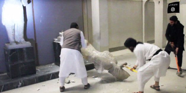 In this image made from video posted on a social media account affiliated with the Islamic State group on Thursday, Feb. 26, 2015, which has been verified and is consistent with other AP reporting, militants take sledgehammers to an ancient artifact in the Ninevah Museum in Mosul, Iraq. The extremist group has destroyed a number of shrines --including Muslim holy sites -- in order to eliminate what it views as heresy. The militants are also believed to have sold ancient artifacts on the black ma