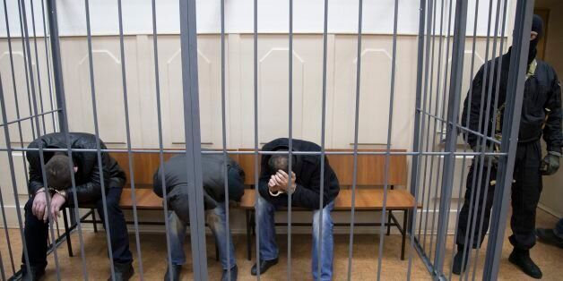 Three men, from the left: Tamerlan Eskerkhanov, Shagid Gubashev and Khamzad Bakhaev suspected of involvement in the killing of Boris Nemtsov sit in a court room in Moscow, Russia, Sunday, March 8, 2015. A Russian court on Sunday charged two men in the killing of leading opposition figure Boris Nemtsov and ordered three other suspects to remain in jail pending a decision on whether to file charges. (AP Photo/Ivan Sekretarev)