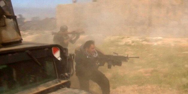 In this still image taken from video soldiers fire towards a target in Tikrit, Iraq on Wednesday, March 11, 2015. Iraqi soldiers and Shiite militiamen entered the Islamic State-held city of Tikrit on Wednesday, authorities said, breaching one of the biggest strongholds of the extremists in a key test for Iraqi forces. (AP Photo)