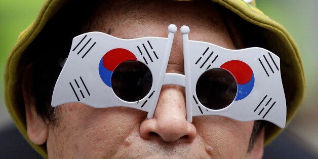 A man with the South Korean flags on his glasses attends during a rally against Japan's Takeshima Day in front of Japanese Embassy in Seoul, South Korea, Sunday, Feb. 22, 2015. Japan's Shimane Prefecture held the annual Takeshima Day ceremony on Sunday, commemorating the Takeshima, the disputed islets called Dokdo in South Korea and Takeshima in Japan. The sovereignty issue over the islands has been the subject of a long territorial dispute between South Korean and Japan. (AP Photo/Lee Jin-man)