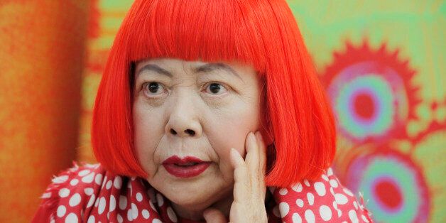 In this photo taken Wednesday, Aug. 1, 2012, Japanese avant-garde artist Yayoi Kusama, wearing a bright red wig and a Louis Vuitton polka dot scarf, speaks during an interview at her studio in Tokyo. Kusama's signature splash of dots has now arrived in the realm of fashion in a new collection from French luxury brand Louis Vuitton - bags, sunglasses, shoes and coats. The latest Kusama collection is showcased at its boutiques around the world, including New York, Paris, Tokyo and Singapore, somet