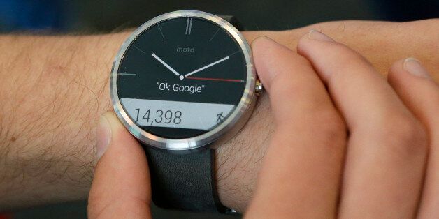 A man wears a Moto 360 by Motorola, an Android Wear smartwatch, on the demo floor at Google I/O 2014 in San Francisco, Wednesday, June 25, 2014. As the Internet giant's Android operating system stretches into cars, homes and smartwatches, this year's annual confab will expand on its usual focus on smartphones and tablets. (AP Photo/Jeff Chiu)