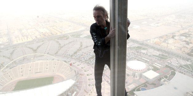 Alain Robert, who has been dubbed the 'French Spiderman', climbs 300 meters up The Torch hotel in Doha on Thursday  April 12, 2012. Robert, who has been scaling tall buildings since the age of seven took 75 minutes to complete his first climb in Qatar of the hotel that was built for the 2006 Asian Games in the shape of an Olympic torch. (AP Photo/Osama Faisal)