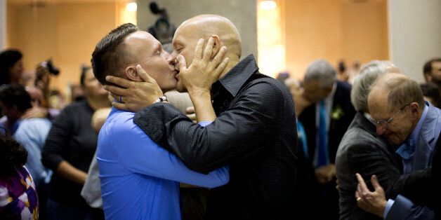 Patrick and Jason Kennedy-Whann kiss after they said their wedding vows during a group wedding Tuesday, Jan. 6, 2015 in Delray Beach, Fla.  Florida's ban on same-sex marriage ended statewide at the stroke of midnight Monday, Jan. 5,  and court clerks in some Florida counties wasted no time, issuing marriage licenses overnight to same-sex couples. But they still were beaten to the punch by a Miami judge who found no need to wait until the statewide ban expired.  (AP Photo/J Pat Carter)