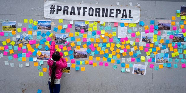 Sophia Lama, 7, of New York, makes sure a message of hope holds onto a wall after on a growing memorial after a deadly earthquake in Nepal, Monday, April 27, 2015, in the Jackson Heights section of the Queens borough of New York. The 7.8 magnitude earthquake on Saturday caused massive devastation, with more than 2,500 people killed and thousands injured in Nepal. It brought down buildings and even a monument, and set off avalanches on Mount Everest. (AP Photo/Craig Ruttle)
