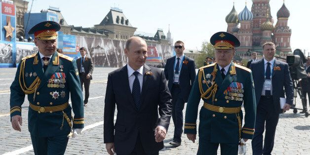 Russian President Vladimir Putin, center, walks after the Victory Parade marking the 70th anniversary of the defeat of the Nazis in World War II, in Red Square, Moscow, Russia, Saturday, May 9, 2015. Defense Minister Sergei Shoigu stands at left and Russian Army ground forces commander Oleg Salyukov at right. (Alexei Nikolsky/RIA Novosti, Kremlin Pool Photo via AP)