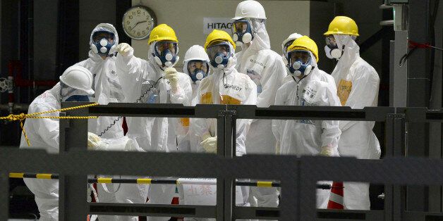 U.S. Ambassador to Japan Caroline Kennedy, front row center, wearing a yellow helmet, a protective suit and a mask, listens to Naohiro Masuda, front row left, an executive of Japan's Tokyo Electric Power Co., when she visits the unit four to inspects the operation to move a spent fuel rod to a cask at the tsunami-crippled Fukushima Dai-ichi nuclear power plant, operated by TEPCO, in Okuma, Fukushima Prefecture, northeastern Japan, Wednesday, May 14, 2014. Kennedy toured the Fukushima Dai-ichi pl