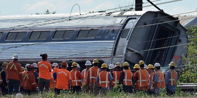 Rescuers gather around a derailed carriage of an Amtrak train in Philadelphia, Pennsylvania, on May 13, 2015. Rescuers on May 13 combed through the mangled wreckage of a derailed train in Philadelphia after an accident that left at least six dead, as the difficult search for possible survivors continued. AFP PHOTO/JEWEL SAMAD        (Photo credit should read JEWEL SAMAD/AFP/Getty Images)