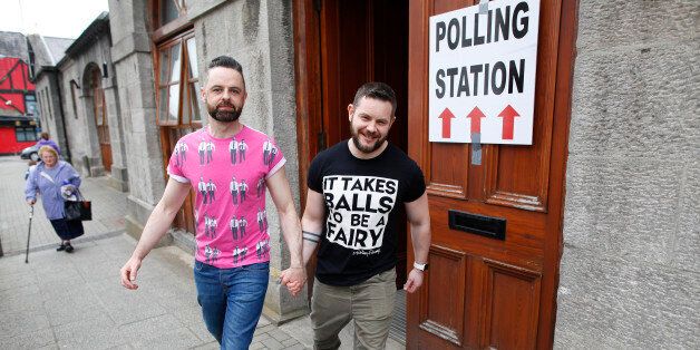 Partners Adrian, centre left and Shane, leave a polling station after casting their vote in Drogheda, Ireland, Friday, May 22, 2015.  Ireland began voting Friday in a referendum on Gay marriage which will require an amendment to the Irish constitution. Opinion polls throughout the two-month campaign suggest the government-backed amendment should be approved by the required majority of voters when results are announced Saturday.  (AP Photo/Peter Morrison)