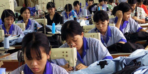 ** FILE ** Vietnamese workers use sewing machines at a state run garment factory to manufacture sporting clothes for the European and U.S. markets in Hanoi in this Sept. 3, 2001 file photo. Vietnam hopes to join the 149-nation global commerce body before it hosts a summit in November of Asia-Pacific Economic Cooperation leaders, including U.S. President George W. Bush. Even as momentum builds, questions linger about whether Vietnam will meet the deadline, and whether it can carve out its market