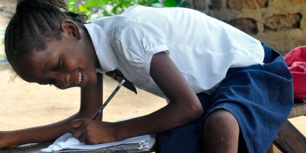 In this photo taken on Friday, May 8, 2015, Mercy Kennedy smiles as she does her home work after school at her home in Monrovia, Liberia. On the day Mercy Kennedy lost her mother to Ebola, it was hard to imagine a time Liberia would be free of one of the worldâs deadliest viruses. It had swept through the 9-year-oldâs neighborhood, killing people house by house. Now seven months later, Liberia on Saturday officially marked the end of the epidemic that claimed more than 4,700 lives here