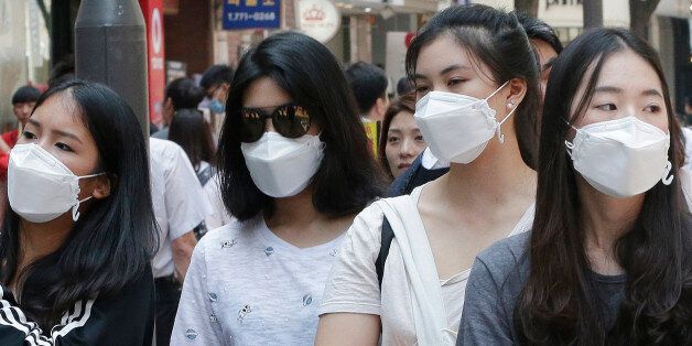 Chinese tourists wear masks as a precaution against the MERS (Middle East Respiratory Syndrome) virus as they walk on the Myeongdong, one of the main shopping districts, in Seoul, South Korea, Thursday, June 4, 2015. The current frenzy in South Korea over MERS brings to mind the other menacing diseases to hit Asia over the last decade _ SARS, which killed hundreds, and bird flu. Then, as now, confusion ruled as the media harped on the growing public panic and health care workers and government o