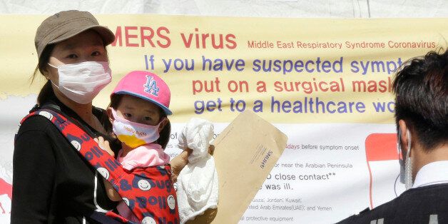 A mother and her daughter wearing masks walk near a precaution against the MERS, Middle East Respiratory Syndrome, virus at a quarantine tent for people who could be infected with the MERS virus at Seoul National University Hospital in Seoul, South Korea, Wednesday, June 3, 2015. South Korea on Tuesday confirmed the country's first two deaths from MERS as it fights to contain the spread of a virus that has killed hundreds of people in the Middle East.(AP Photo/Ahn Young-joon)