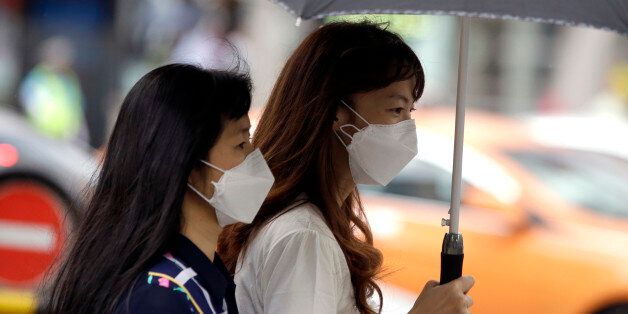 Tourists wear masks as a precaution against MERS (Middle East Respiratory Syndrome) at a shopping district in Seoul, South Korea, Friday, June 5, 2015. Sales of surgical masks surge amid fears of a deadly, poorly understood virus. Despite media warnings about the virus