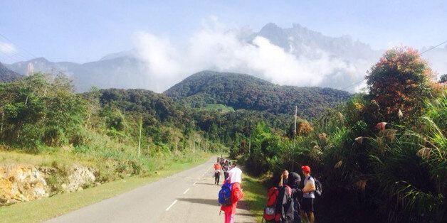 Tourists walk away from Mount Kinabalu hours after a magnitude 5.9 earthquake shook the area in Kundasang, Sabah, Malaysia, Friday, June 5, 2015.