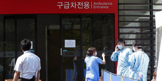 Hospital workers wear masks as a precaution against the MERS, Middle East Respiratory Syndrome, virus as they work in front of  an emergency room of Samsung Medical Center in Seoul, South Korea, Sunday, June 7, 2015. A fifth person in South Korea has died of the MERS virus, as the government announced Sunday it was strengthening measures to stem the spread of the disease and public fear.(AP Photo/Ahn Young-joon)