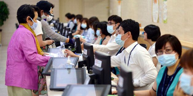 Hospital workers, right, wear masks as a precaution against Middle East Respiratory Syndrome virus as they talk with visitors at Chonnam University Hospital in Gwangju, South Korea, Monday, June 8, 2015. South Korea on Monday reported its sixth death from MERS as authorities were bolstering measures to stem the spread of the virus that has left dozens of people infected. (Yun Hyung-geun/Newsis via AP) KOREA OUT