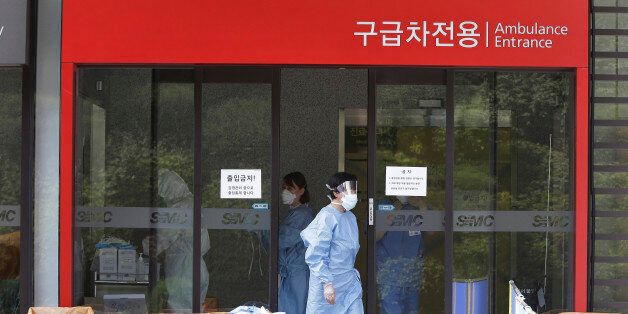 A hospital worker wears a mask as a precaution against the MERS, Middle East Respiratory Syndrome, virus as she comes out from an emergency room of Samsung Medical Center in Seoul, South Korea, Sunday, June 7, 2015. A fifth person in South Korea has died of the MERS virus, as the government announced Sunday it was strengthening measures to stem the spread of the disease and public fear.(AP Photo/Ahn Young-joon)