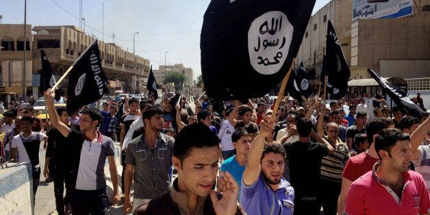 FILE - In this Monday, June 16, 2014 file photo, demonstrators chant pro-Islamic State group slogans as they wave the group's flags in front of the provincial government headquarters in Mosul, 225 miles (360 kilometers) northwest of Baghdad, Iraq. The IS declaration of a