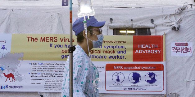 A patient wearing a mask as a precaution against the MERS, Middle East Respiratory Syndrome, virus walks by a facility to examine temporarily quarantined people who could be infected with the MERS virus at Seoul National University Hospital in Seoul, South Korea Monday, June 1, 2015. More than 680 people in South Korea are isolated after having contact with patients infected with the virus that has killed hundreds of people in the Middle East, health officials said Monday. (AP Photo/Ahn Young-jo
