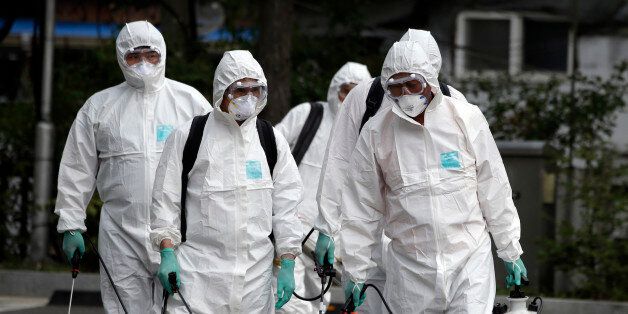 Workers wearing protective gears arrive to spray antiseptic solution as a precaution against the spread of Middle East Respiratory Syndrome (MERS) at an art hall in Seoul, South Korea, Friday, June 12, 2015. South Korea on Friday reported an 11th death from the MERS virus outbreak, but officials said they are seeing a fewer number of new infections and that it was unlikely there would be another large outbreak. (AP Photo/Lee Jin-man)