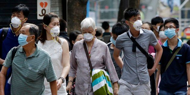 Visitors wearing masks as a precaution against the MERS (Middle East Respiratory Syndrome) virus walk at a shopping district in Seoul, South Korea, Tuesday, June 16, 2015. The death toll continued to mount in South Korea's MERS outbreak on Tuesday even as schools reopen and people recover from the virus. (AP Photo/Lee Jin-man)