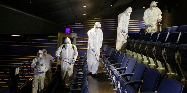 Workers wearing protective gear spray antiseptic solution as a precaution against the spread of the MERS virus at Uniplex Art Center in Seoul, South Korea, Thursday, June 17, 2015. The head of the World Health Organization on Thursday praised beleaguered South Korean officials and exhausted health workers, saying their efforts to contain a deadly MERS virus outbreak have put the country on good footing and lowered the public risk. (AP Photo/Ahn Young-joon)