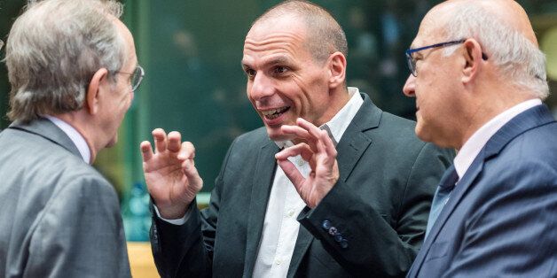 Greek Finance Minister Yanis Varoufakis, center, gestures as he talks with Italian Finance Minister Pier Carlo Padoan, left, and French Finance Minister Michel Sapin during a meeting of eurozone finance ministers in Brussels on Thursday, June 25, 2015. Greece and its creditors launched a new round of talks in Brussels early Thursday in a fresh bid to unlock billions of euros in loans and save the country from bankruptcy. (AP Photo/Geert Vanden Wijngaert)