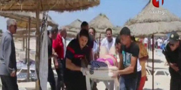 In this screen grab taken from video provided by Tunisia TV1, injured people are treated on a Tunisian beach Friday June 26, 2015. Two gunmen rushed from the beach into a hotel in the Tunisian resort town of Sousse Friday, killing at least 27 people and wounding six others in the latest attack on the North African country's key tourism industry, the Interior Ministry said. (Tunisia TV1 via AP) MANDATORY CREDIT