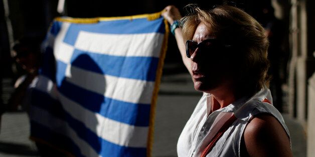People protest during a pro Greece demonstration at the European Union Office in Barcelona, Spain, Monday, June 29, 2015. Spain's economy minister has said a Greek debt deal is still reachable, although Spain's benchmark Ibex stock index slid nearly 4 percent Monday morning. (AP Photo/Manu Fernandez)