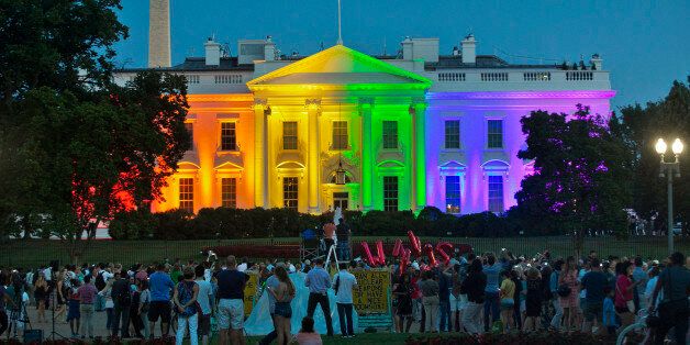FILE - In this Friday, June 26, 2015 file photo, people gather in Lafayette Park to see the White House illuminated with rainbow colors in commemoration of the Supreme Court's ruling to legalize same-sex marriage in Washington. (AP Photo/Pablo Martinez Monsivais)