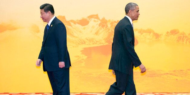 U.S. President Barack Obama walks past Chinese President Xi Jinping during a welcome ceremony for the Asia-Pacific Economic Cooperation (APEC) Economic Leaders Meeting held at the International Convention Center in Yanqi Lake, Beijing, on Tuesday, Nov 11, 2014. (AP Photo/Ng Han Guan)