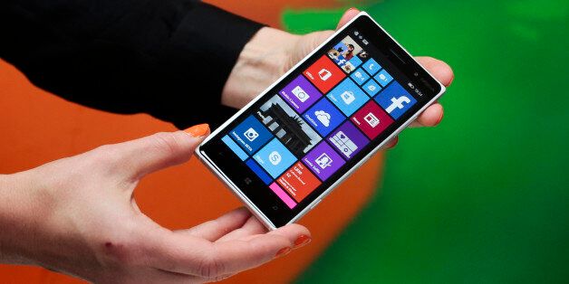 A woman shows the new Lumia 830 smart phone during a Microsoft Nokia presentation event at the consumer electronic fair IFA in Berlin, Thursday, Sept. 4, 2014. (AP Photo/Markus Schreiber)