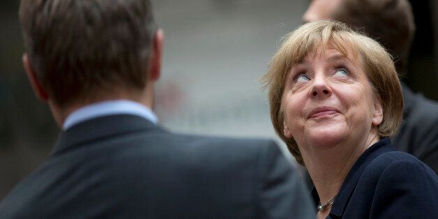 German Chancellor Angela Merkel looks up as she arrives for an emergency summit of eurozone heads of state or government at the EU Council building in Brussels on Tuesday, July 7, 2015. Greek Prime Minister Alexis Tsipras was heading Tuesday to Brussels for an emergency meeting of eurozone leaders, where he will try to use a resounding referendum victory to eke out concessions from European creditors over a bailout for the crisis-ridden country. (AP Photo/Virginia Mayo)