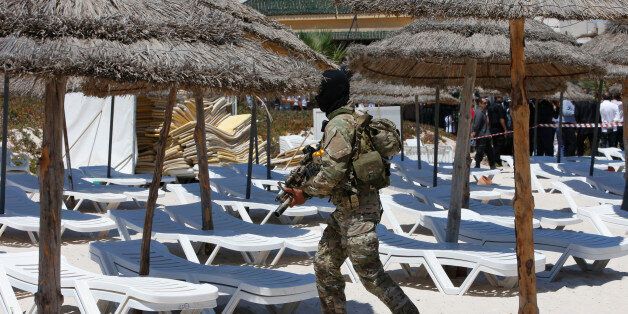 A hooded Tunisian police officer patrols  ahead of the visit of top security officials of Britain, France, Germany and Belgium at the scene of Friday's shooting attack in front of the Imperial Marhaba hotel in the Mediterranean resort of Sousse, Tunisa, Monday, June 29, 2015. The top security officials of Britain, France, Germany and Belgium are paying homage to the people killed in the terrorist attack on Friday. (AP Photo/Abdeljalil Bounhar)