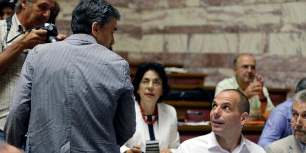 Greek Finance Minister Euclid Tsakalotos, left, speaks with Parliament Member Yanis Varoufakis before a meeting with lawmakers of Syriza party at the Greek Parliament in Athens, Friday, July 10, 2015. Greece's Prime Minister Alexis Tsipras will seek backing for a harsh new austerity package from his party Friday to keep his country in the euro â less than a week after urging Greeks to reject milder cuts in a referendum. (AP Photo/Thanassis Stavrakis)
