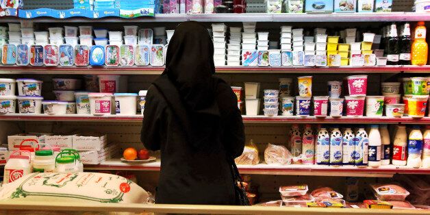 An Iranian woman looks at goods on the shelves in a supermarket in north Tehran, Iran, Wednesday, April 29, 2015. Iran has scrapped the country's wealthiest citizens off a list of people receiving monthly cash handouts in a small step toward easing the burden on the budget and freeing up more government funds, an official said Wednesday. The move, which will free up about $3 million a month of government money, is the latest in Tehran's efforts to juggle cash and wean the nation off subsidies in