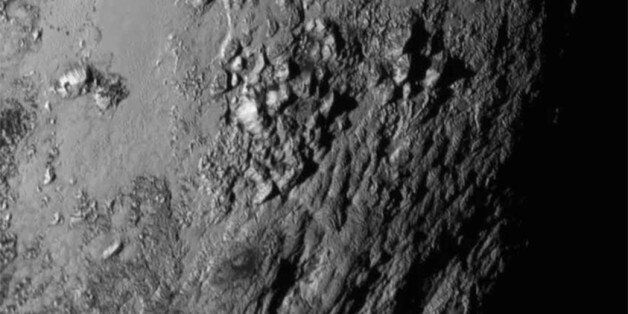 This Tuesday, July 14, 2015 image provided by NASA on Wednesday shows a region near Pluto's equator with a range of mountains captured by the New Horizons spacecraft. (NASA/JHUAPL/SwRI via AP)
