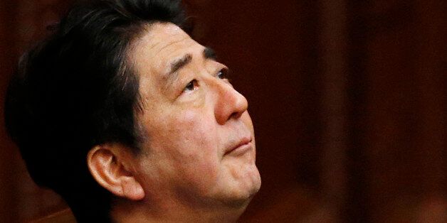 Japanese Prime Minister Shinzo Abe, looks up during a plenary session at the lower house in Tokyo, Thursday, July 16, 2015.  Japan's lower house of parliament on Thursday approved legislation that would allow an expanded role for the nation's military in a vote boycotted by the opposition. Shigeru Ishiba, the minister for Vitalizing Local Economy in Japan is seen at left.(AP Photo/Shuji Kajiyama)