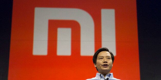 Xiaomi Chairman Lei Jun stands in front of the logo of the Chinese smartphone maker, at a press event in Beijing, Thursday, Jan. 15, 2015. The Chinese manufacturer on Thursday unveiled a new model that Lei said has processor size and performance comparable to Appleâs iPhone 6 but is thinner and lighter. (AP Photo/Ng Han Guan)