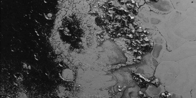 This image was taken on July 14, 2015, by New Horizonsâ Long Range Reconnaissance Imager (LORRI) from a distance of 48,000 miles (77,000 kilometers) shows a newly discovered mountain range near the southwestern margin of Plutoâs Tombaugh Regio (Tombaugh Region), situated between bright, icy plains and dark, heavily-cratered terrain.  The image was received on Earth on July 20. (NASA/JHUAPL/SWRI via AP)