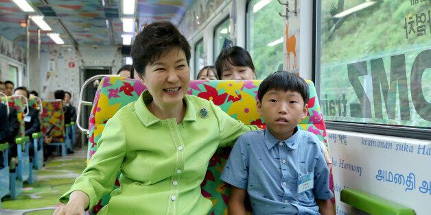 박근혜 대통령이 5일 강원도 철원군 백마고지역으로 가는 경원선 열차에서 탈북자 자녀 이정민군과 함께 앉아 있다.