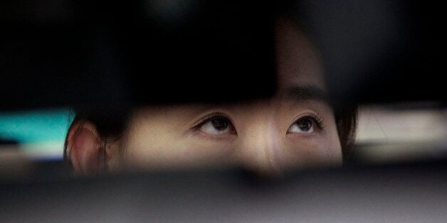 A currency trader watches monitors at the foreign exchange dealing room of the Korea Exchange Bank headquarters in Seoul, South Korea, Friday, July 11, 2014. Asian stock markets were muted Friday, following the lead of Wall Street traders spooked by worries about the soundness of a bank in Portugal that raised the specter of more financial turmoil in Europe. South Korea's benchmark Kospi dropped 0.70 percent at 1,988.74.( AP Photo/Ahn Young-joon).