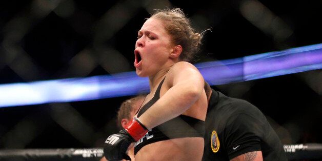 Ronda Rousey celebrates defeating Liz Carmouche after their UFC 157 women's bantamweight championship mixed martial arts match in Anaheim, Calif., Saturday, Feb. 23, 2013. Rousey won the first womenâs bout in UFC history, forcing Carmouche to tap out in the first round. (AP Photo/Jae C. Hong)