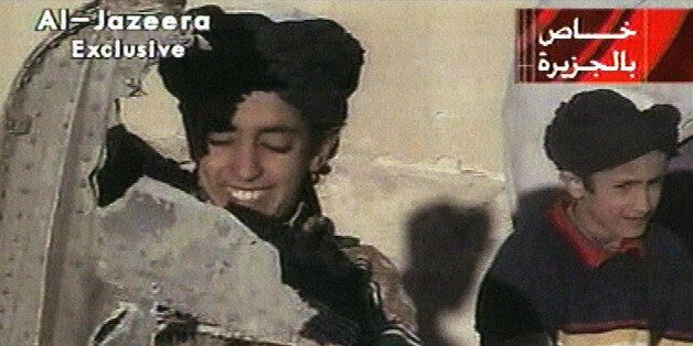 In this image made from video broadcast by the Qatari-based satellite television station Al-Jazeera Wednesday, Nov. 7, 2001, a young boy, left, identified as Hamza bin Laden holds what the Taliban says is a piece of U.S. helicopter wreckage in Ghazni, Afghanistan on Monday, Nov. 5, 2001. The Qatar based broadcaster identified the boy as one of the sons of Osama bin Laden, the prime suspect in the Sept. 11, attacks on the United States. Boy at right is unidentified. Graphic at top right reads