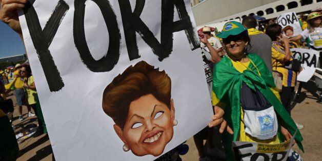 A demonstrator shows a poster that reads in Portuguese
