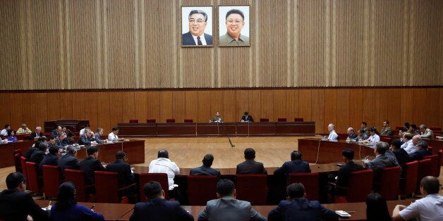 North Korea's General Reconnaissance Bureau Director Kim Yong Chol, center left, sits under the portraits of the late North Korean leaders, Kim Il Sung, left, and Kim Jong Il, as he speaks during a briefing for foreign diplomats regarding the latest situation at the border between the two Koreas at the People's Cultural House in Pyongyang, North Korea, Friday, Aug. 21, 2015. North Korean leader Kim Jong Un on Friday declared his frontline troops in a