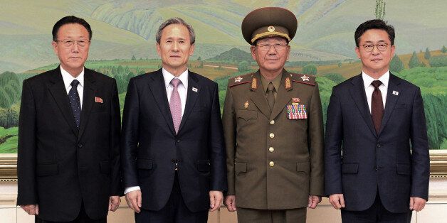 In this photo provided by the South Korean Unification Ministry, South Korean Unification Minister Hong Yong-pyo, right, and presidential security adviser Kim Kwan-jin, second from left,  pose with Kim Yang Gon, right, a senior North Korean official responsible for South Korean affairs, and Hwang Pyong So, North Korea' top political officer for the Korean People's Army, after their meeting at the border village of Panmunjom in Paju, South Korea, Tuesday, Aug. 25, 2015. South Korea has agreed to